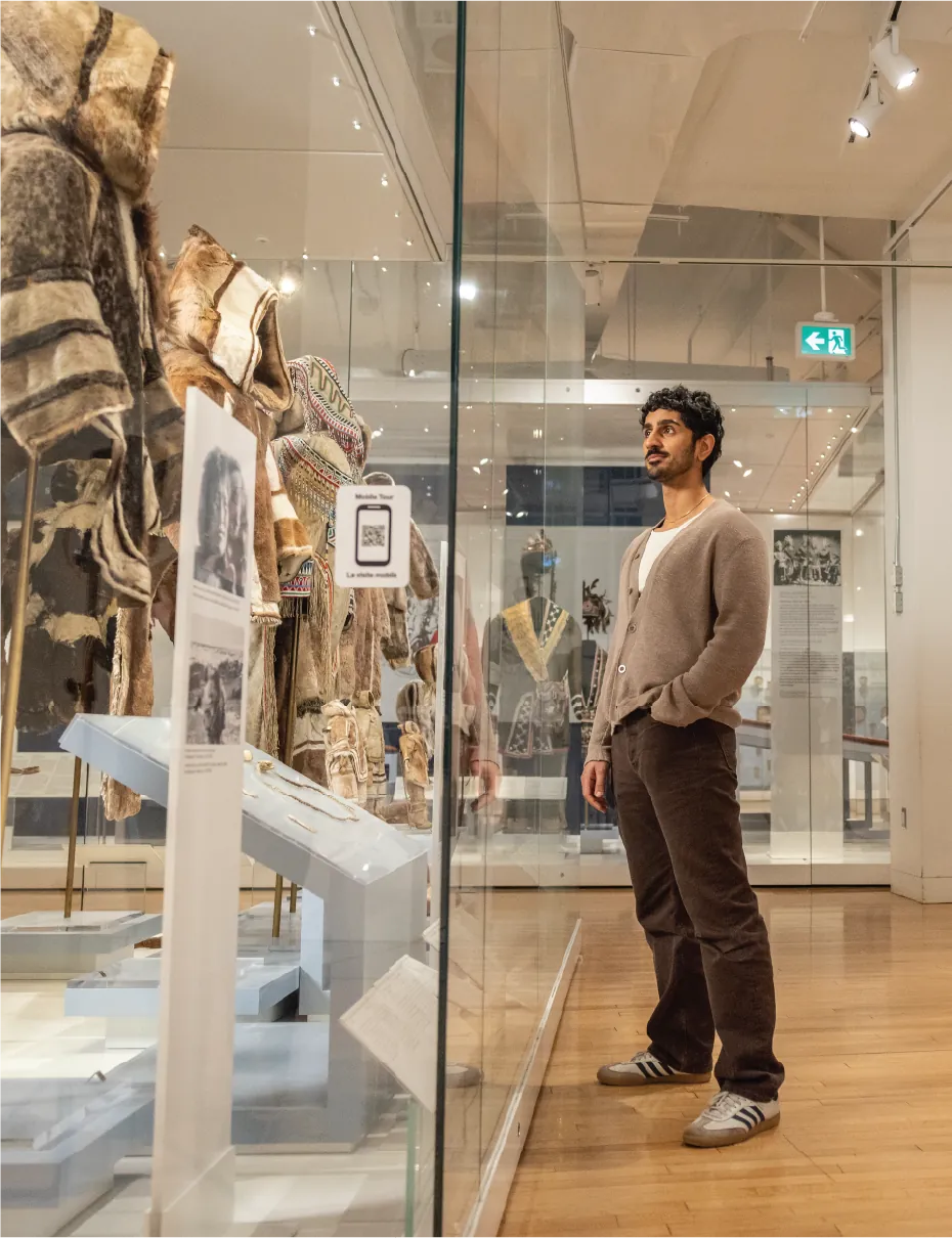 Visitor viewing cultural artifacts at ROM.