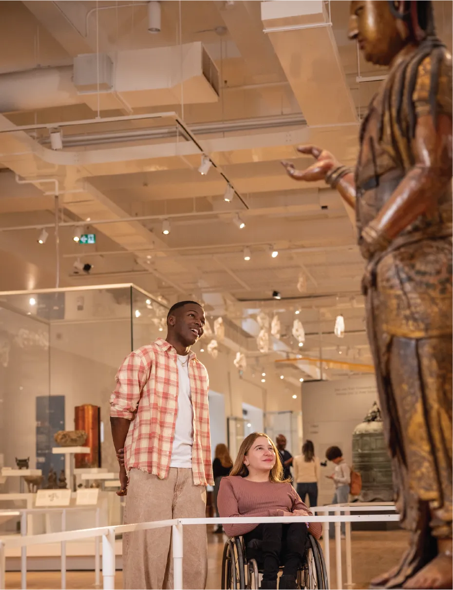 Visitors exploring ROM exhibit featuring a large sculpture.